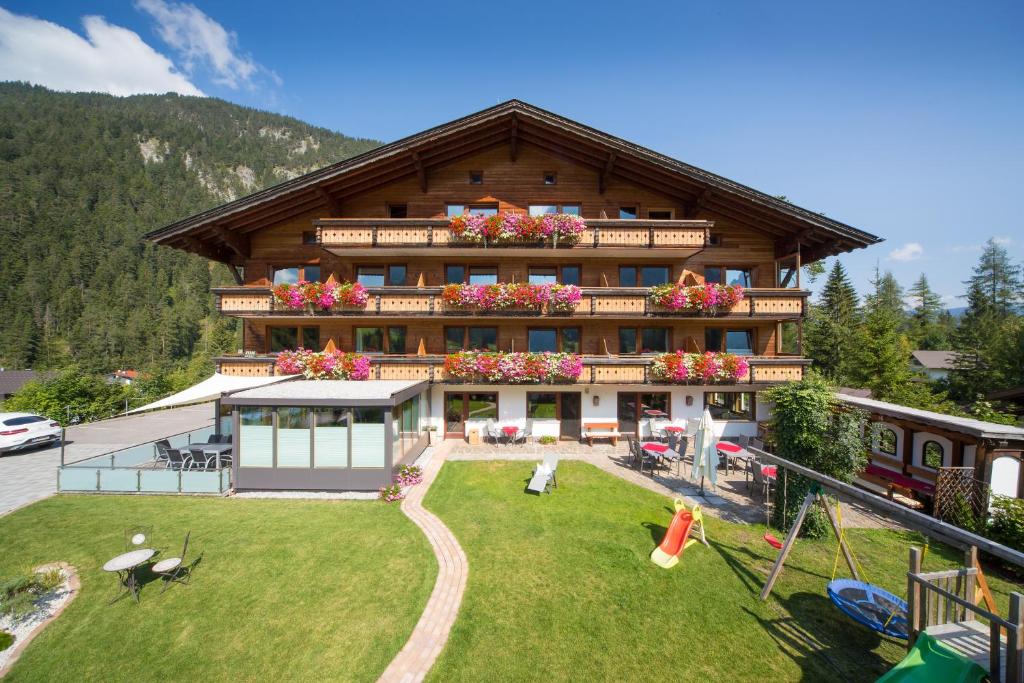 ein großes Haus mit einem Spielplatz davor in der Unterkunft Das ALPSPITZ in Biberwier