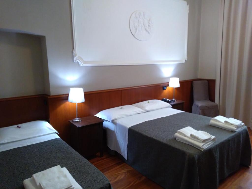 um quarto de hotel com duas camas com toalhas em Hotel Twenty Nine em Gênova