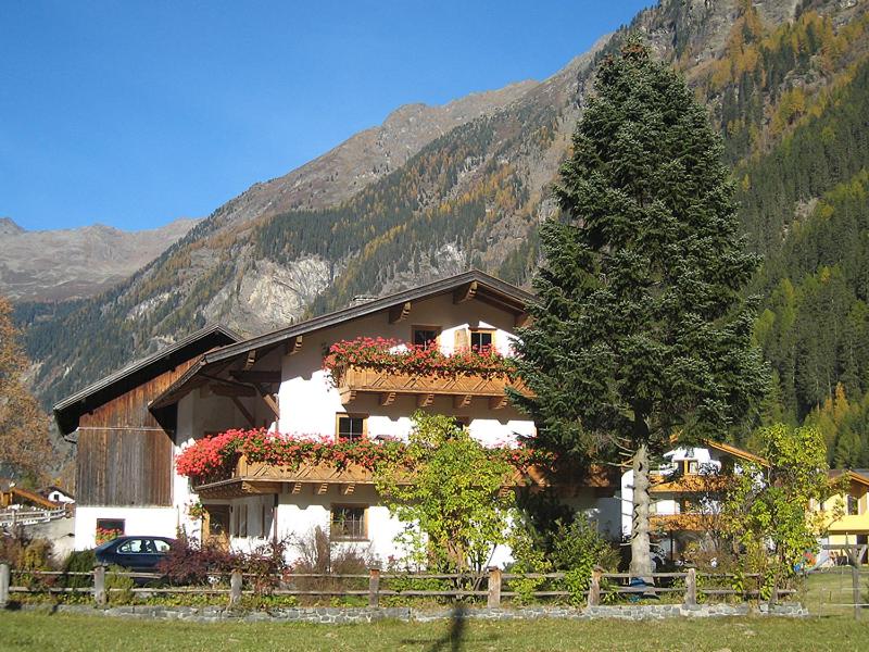 a building with flower boxes on it in front of a mountain at Plattnerhof Kaunertal in Kaunertal