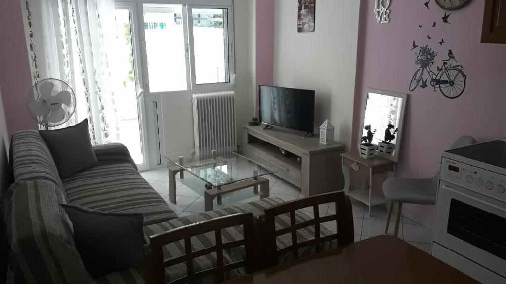 uma sala de estar com um sofá e uma televisão em Dimos em Tessalónica