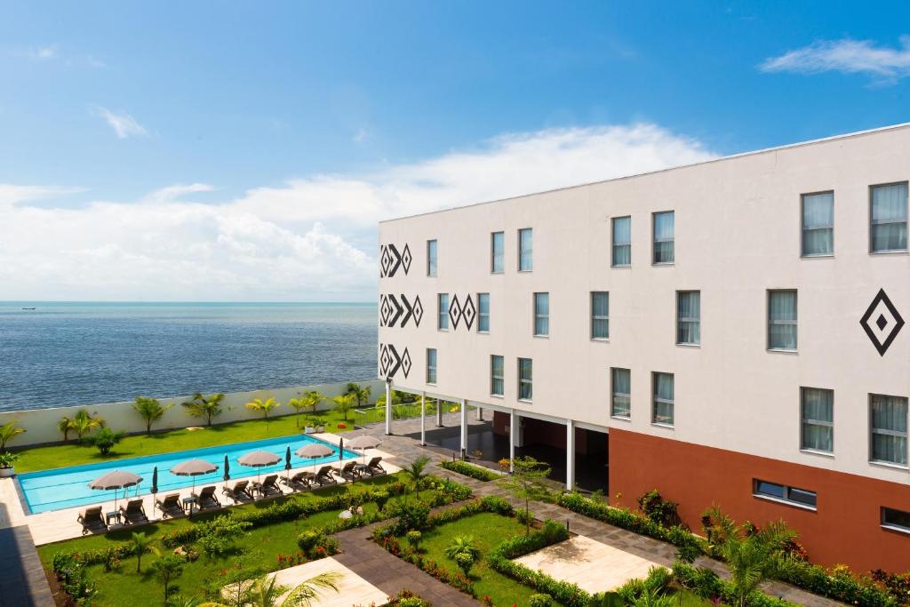 - une vue aérienne sur le complexe et l'océan en arrière-plan dans l'établissement ONOMO Hotel Conakry, à Conakry
