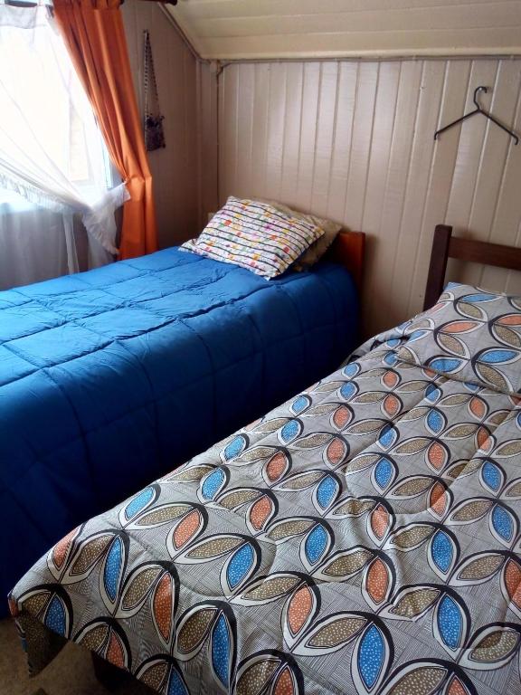 a bedroom with two beds and a window at Hospedaje Alicia Acuna in Quepe