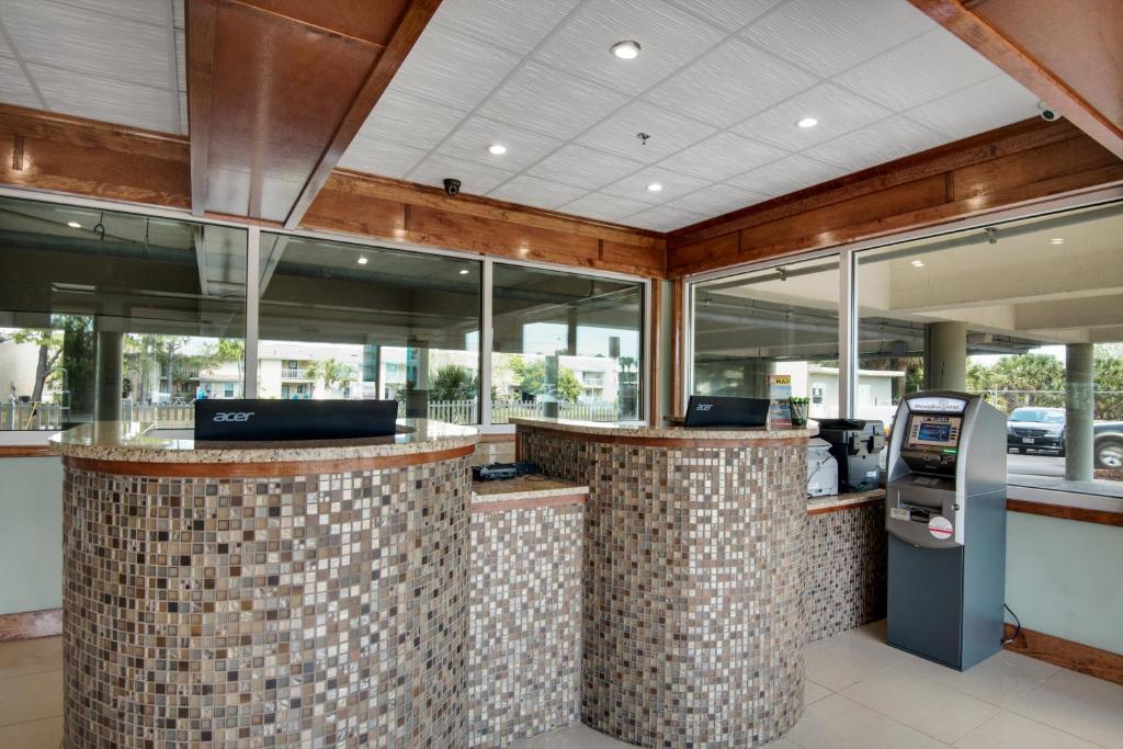 a restaurant with a ticket counter with a ticket machine at Baymont by Wyndham Panama City Beach in Panama City Beach