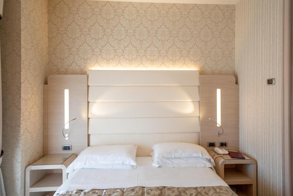 A bed or beds in a room at Hotel Capri Bardolino 3S