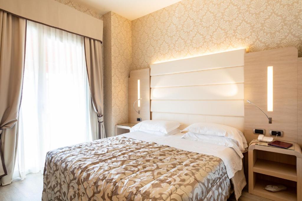 A bed or beds in a room at Hotel Capri Bardolino 3S