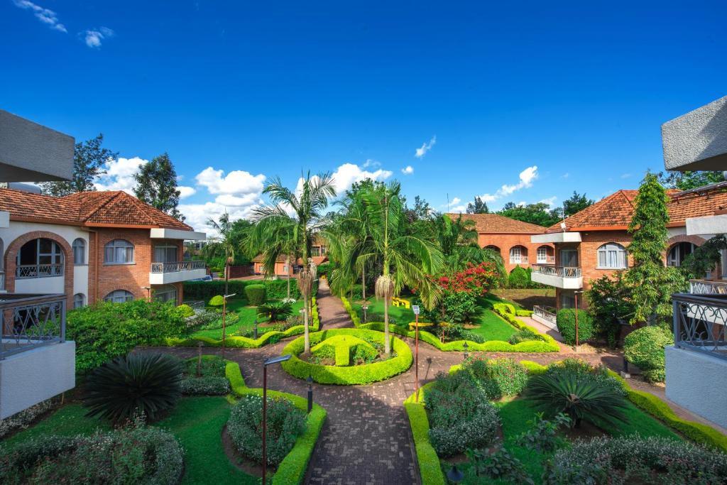 - une vue aérienne sur un jardin planté de palmiers et de buissons dans l'établissement Hotel Chez Lando, à Kigali