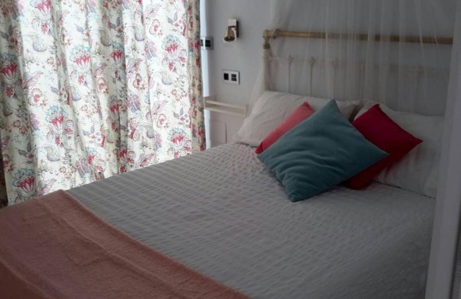 a bed with two pillows on it in a bedroom at Apartamentos en Paseo Maritimo in El Rompido