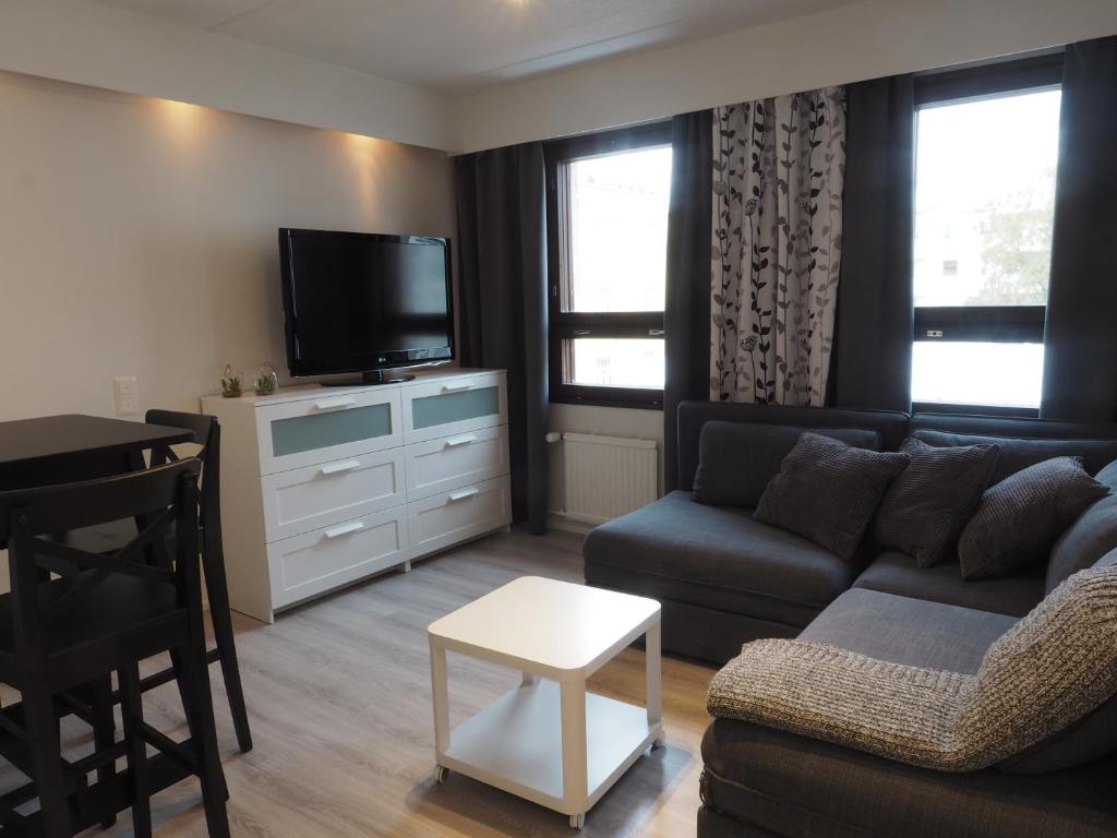 uma sala de estar com um sofá e uma televisão em Apartment Oulu station em Oulu