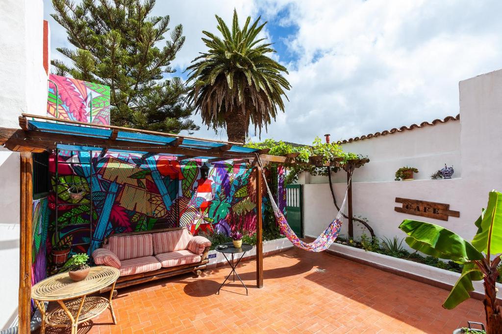 un patio con un columpio y una casa en Patio Hostel en La Laguna