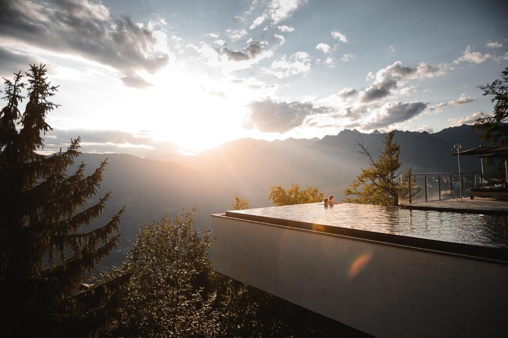 a view of the sun rising over the mountains at Miramonti Boutique Hotel in Avelengo