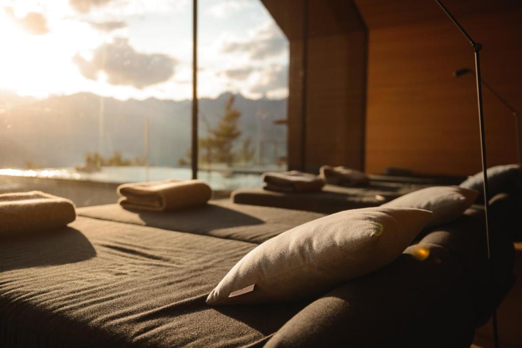 a row of beds with pillows in a room at Miramonti Boutique Hotel in Avelengo