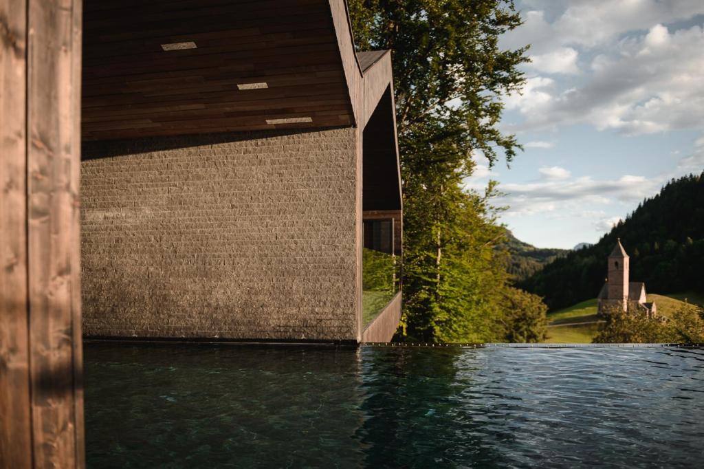a house on a body of water at Miramonti Boutique Hotel in Avelengo