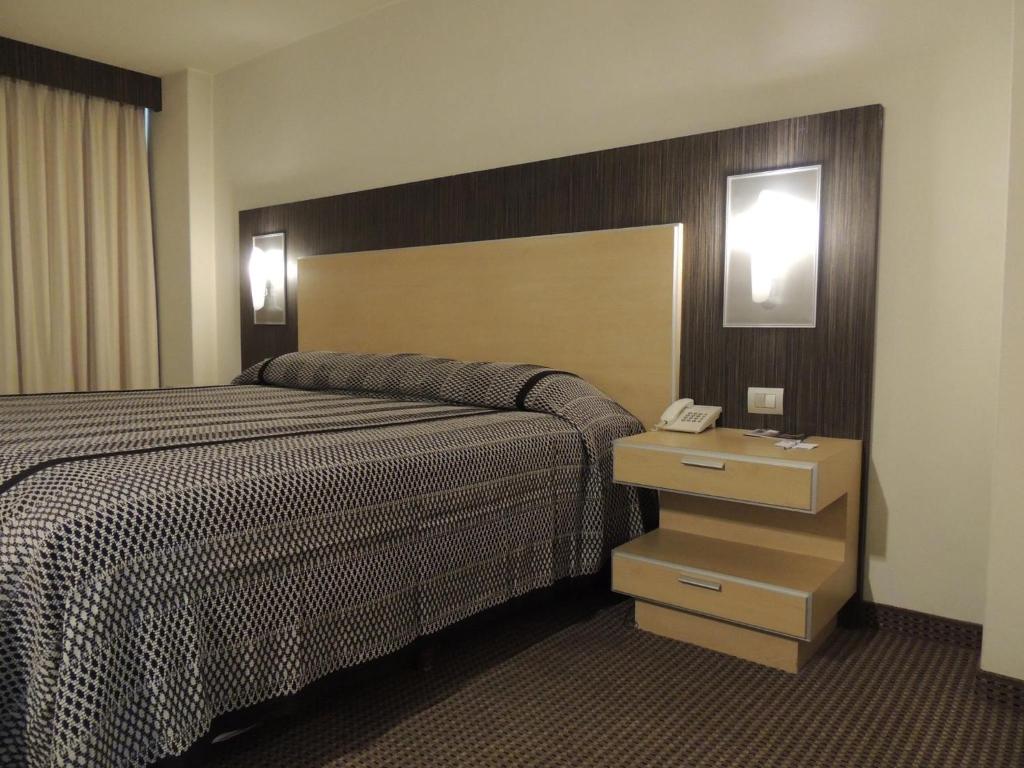 a hotel room with a bed and a telephone at Lisboa Hotel in Mexico City