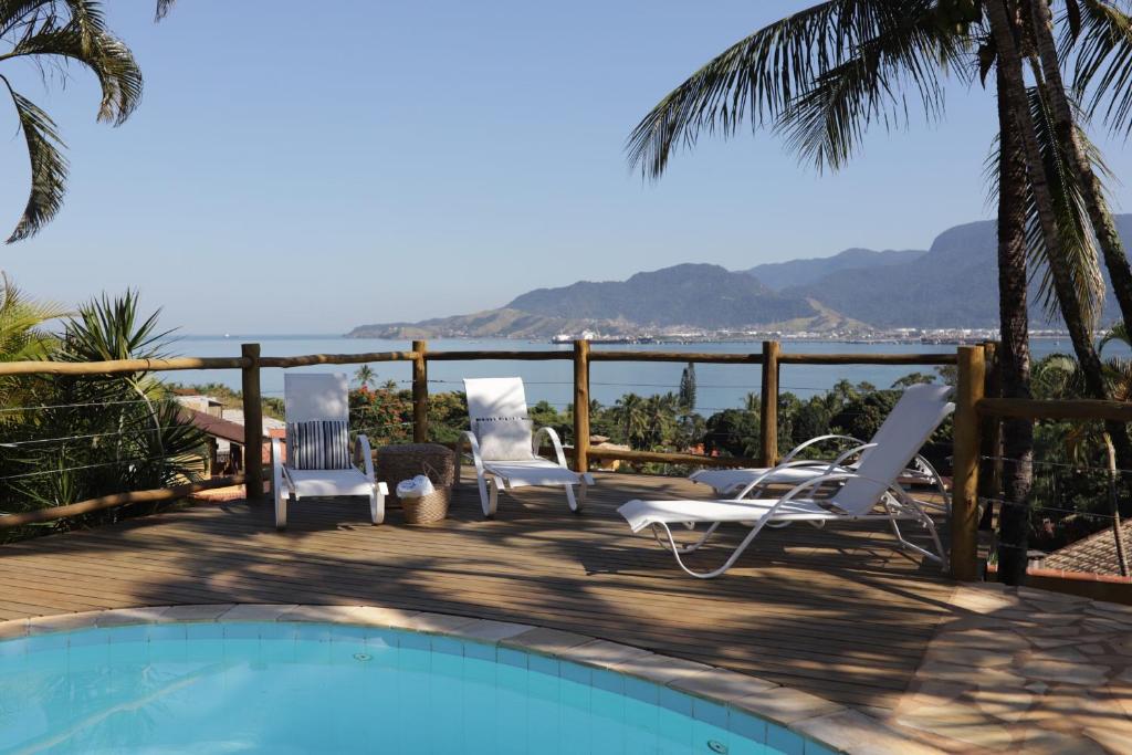 een terras met stoelen en een zwembad bij Pousada Altamira in Ilhabela