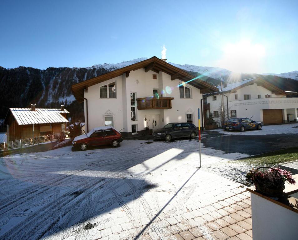 ein Gebäude mit Autos auf einem Parkplatz in der Unterkunft Apart Fortuna in Samnaun