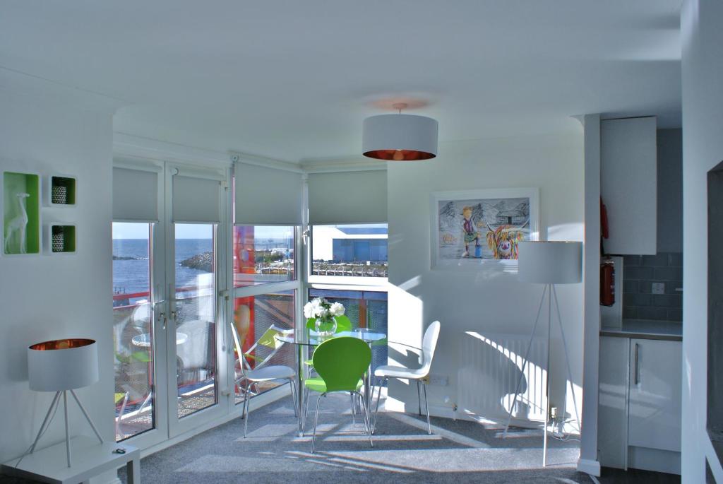 een woonkamer met een tafel en stoelen en een balkon bij No27 Ayr Beach - Coorie Doon Stays in Ayr