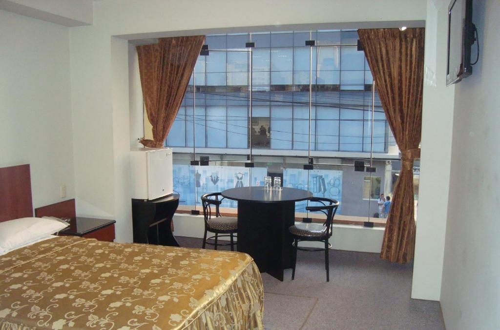 Habitación con cama, mesa y ventana en Hostal Bond en Lima