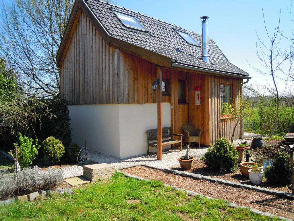 a small house with a bench in a yard at Holiday home Brokantie in Pamel