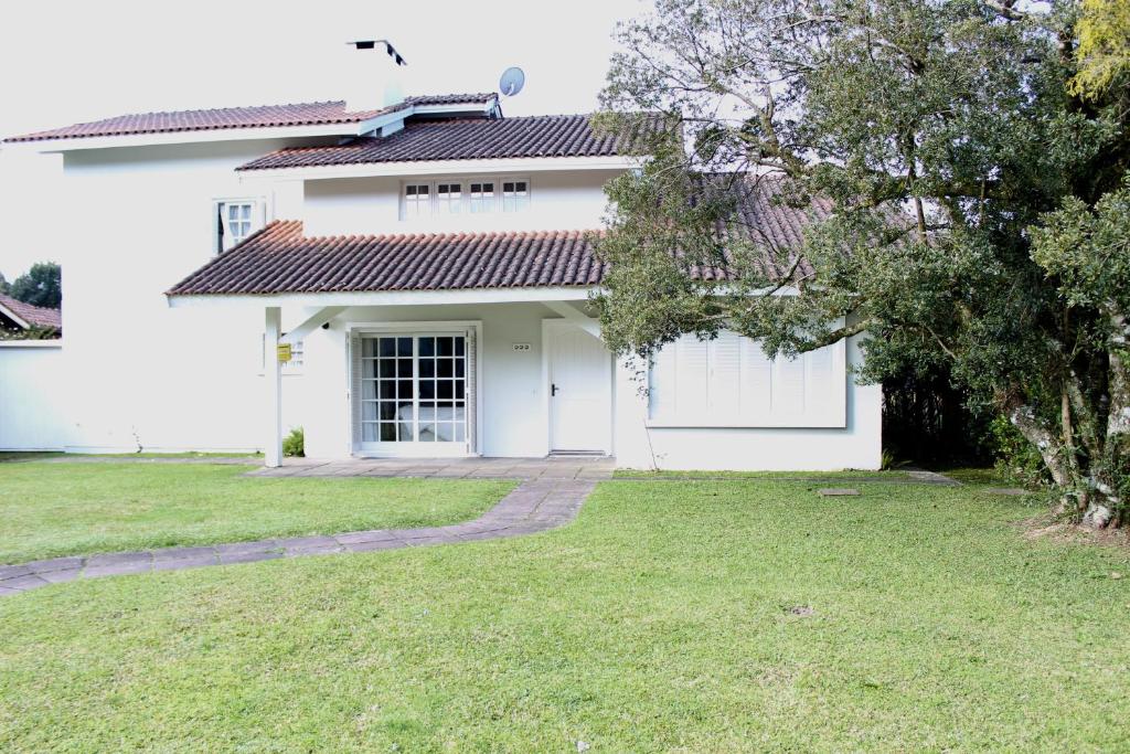 una casa blanca con un patio delante en Residencial Luíza, en Canela