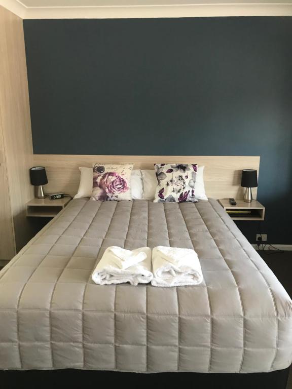 una camera da letto con un grande letto con due asciugamani di Kootingal Landview Motel a Kootingal