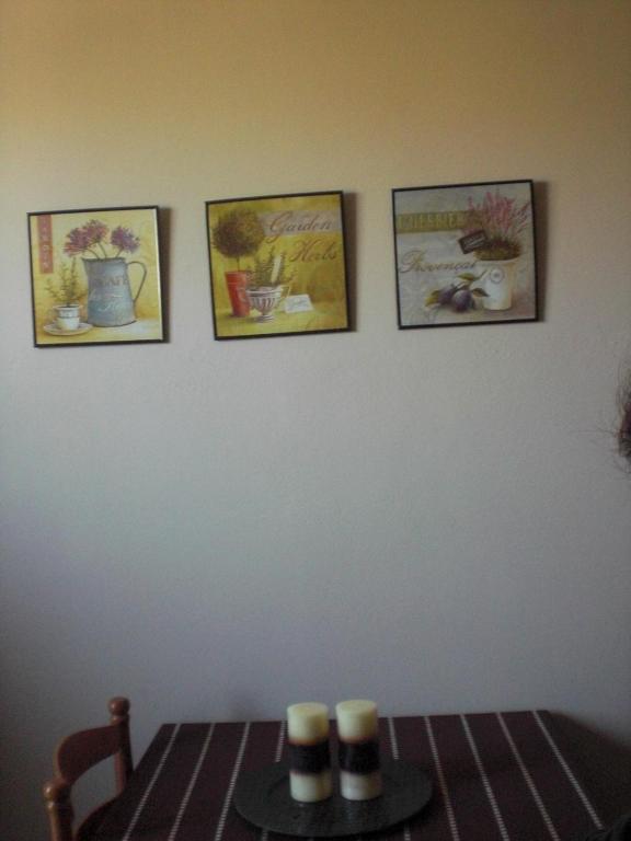 a dining room table with three pictures on the wall at Villa Elena in Lixouri