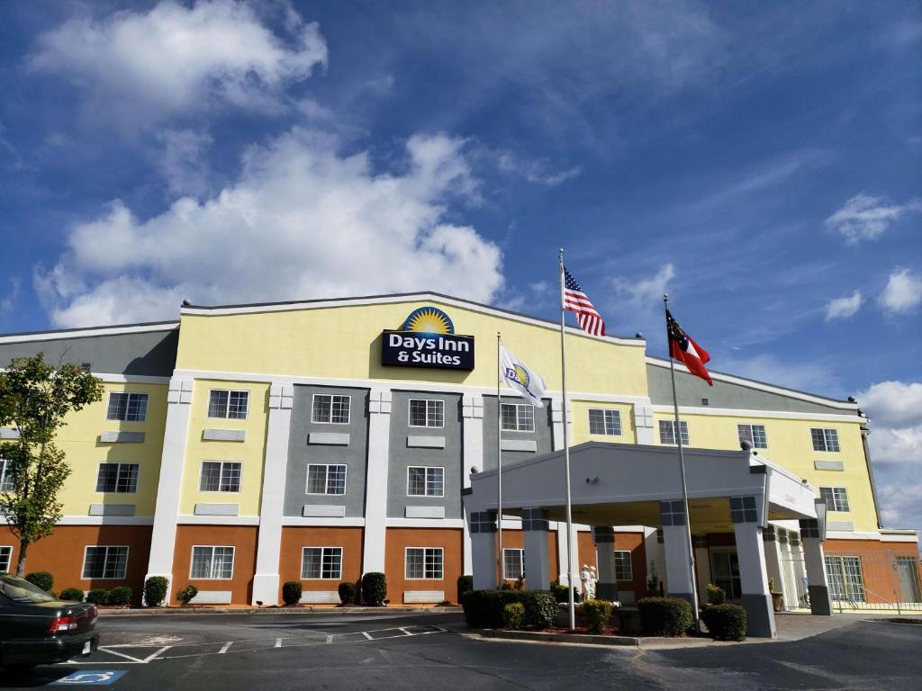 a front view of a hotel with two american flags at Days Inn & Suites by Wyndham Union City in Union City