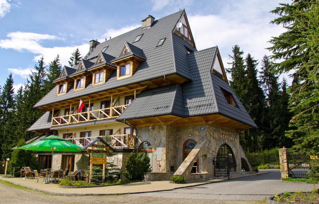 una casa grande con techo de gambrel en Pensjonat Reymontówka, en Kościelisko