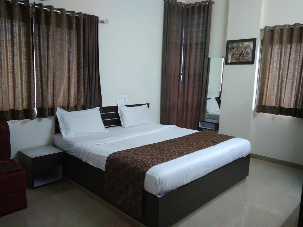 ein Schlafzimmer mit einem großen Bett in einem Zimmer in der Unterkunft Balaji Lodging in Pandharpur