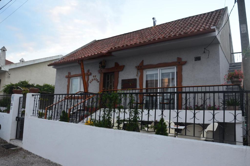 a white house with a balcony with a fence at Os Piratas in Charneca