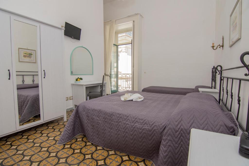 a bedroom with a bed with a purple blanket at Hotel Fontana in Amalfi