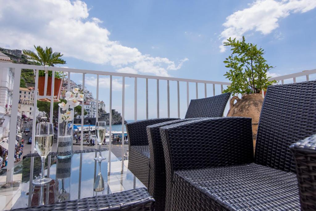 a balcony with two chairs and a glass table at Hotel Fontana in Amalfi