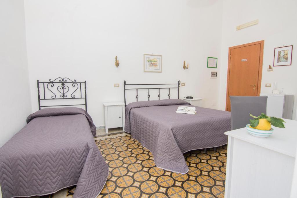 two beds sitting next to each other in a room at Hotel Fontana in Amalfi