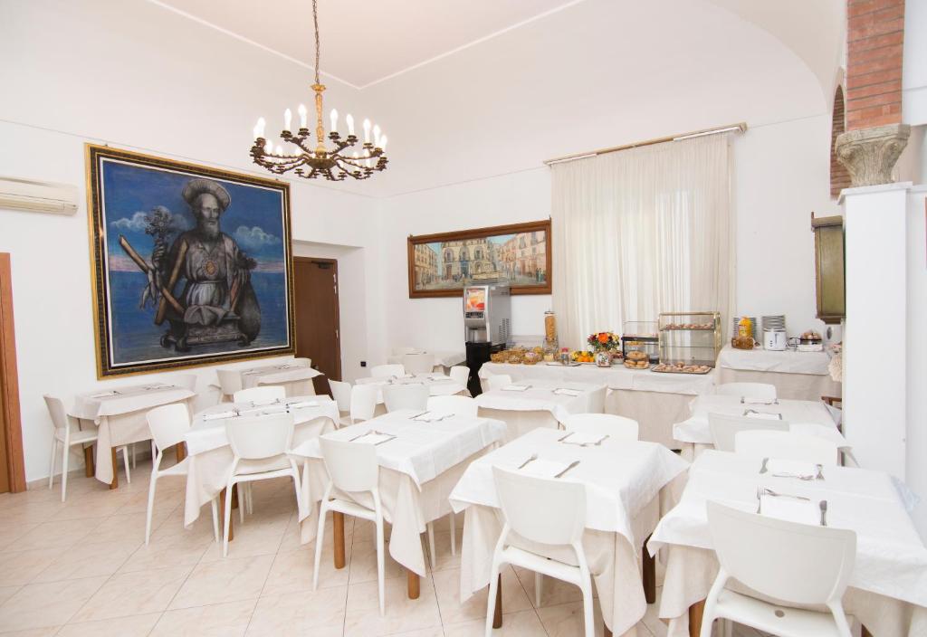 a dining room with white tables and white chairs at Hotel Fontana in Amalfi