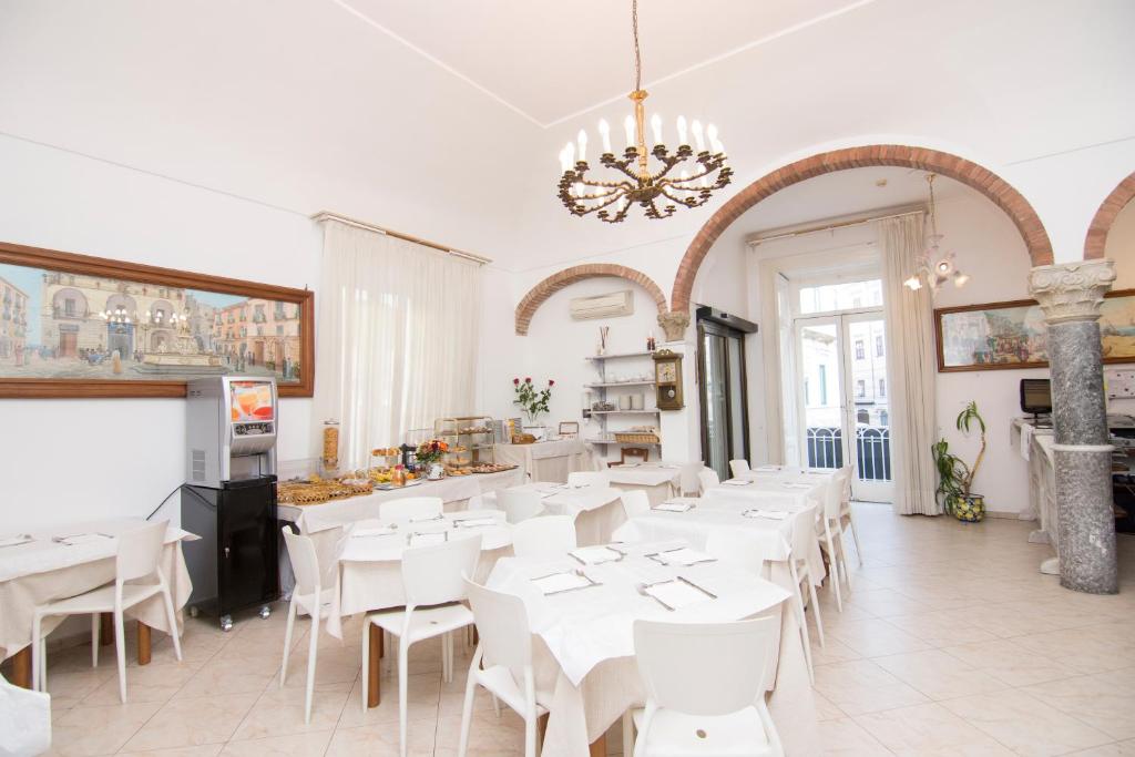 a dining room with white tables and white chairs at Hotel Fontana in Amalfi