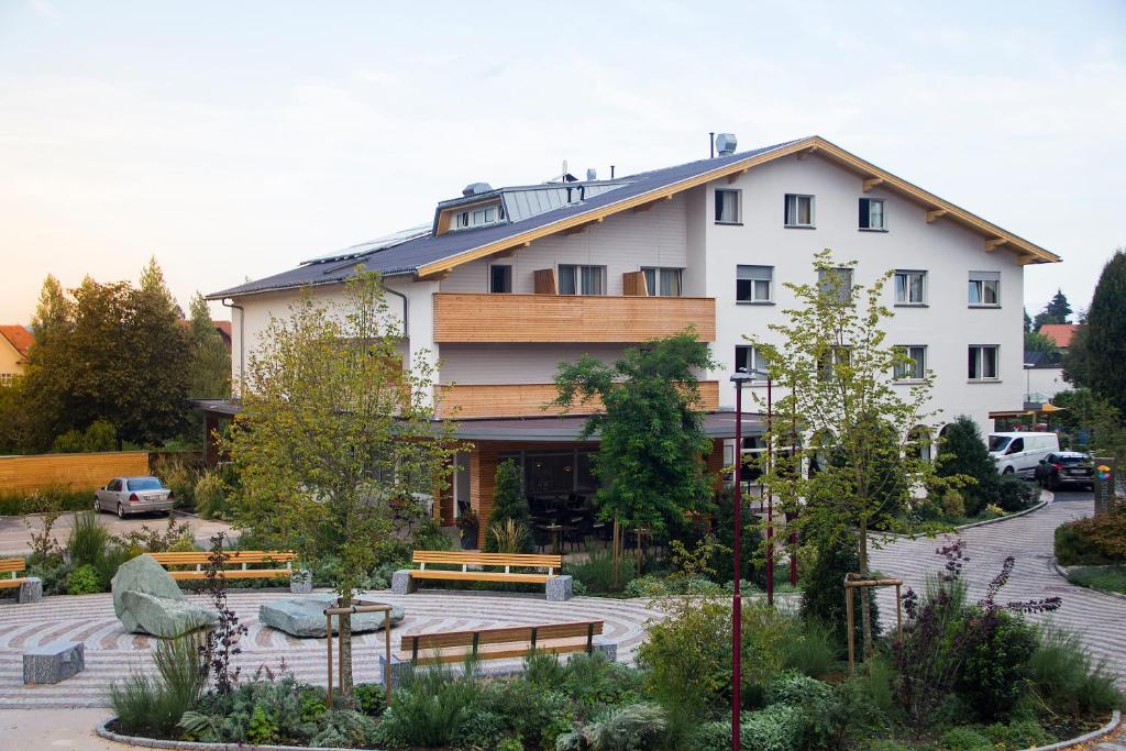 ein großes weißes Gebäude mit Bänken im Innenhof in der Unterkunft Die Linde in Höchst