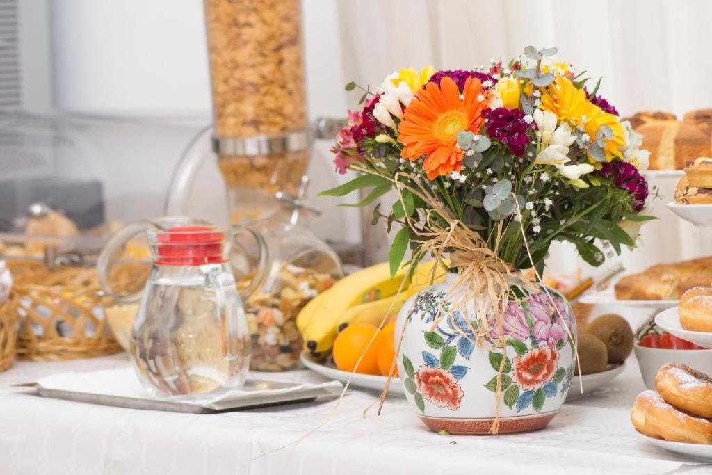 a vase filled with flowers on a table with food at Hotel Fontana in Amalfi