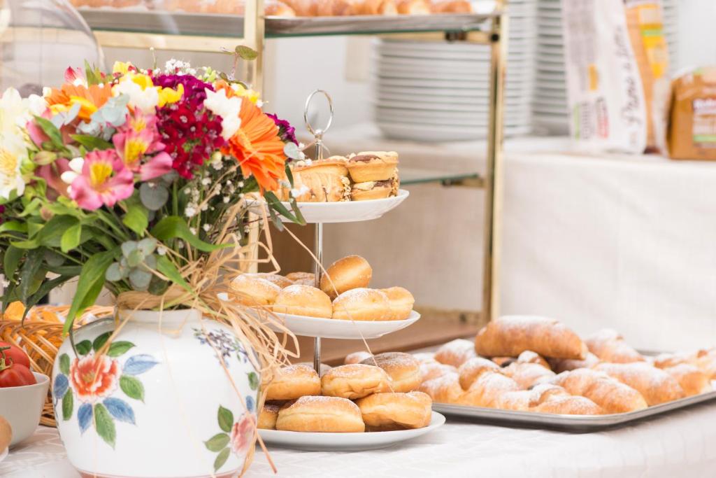 a table with two plates of pastries and a vase with flowers at Hotel Fontana in Amalfi