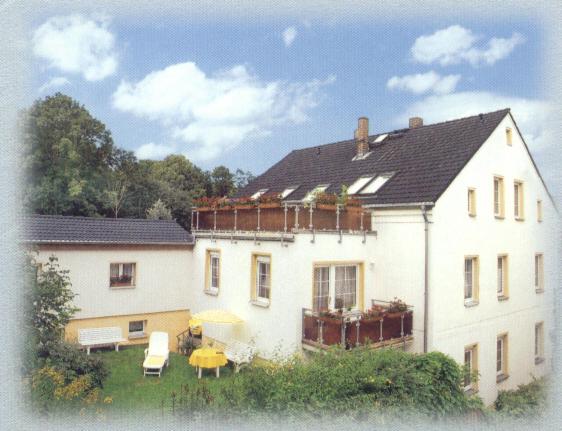 Casa blanca grande con mesa y sillas en Ferienwohnungen Bochmann, en Schneeberg