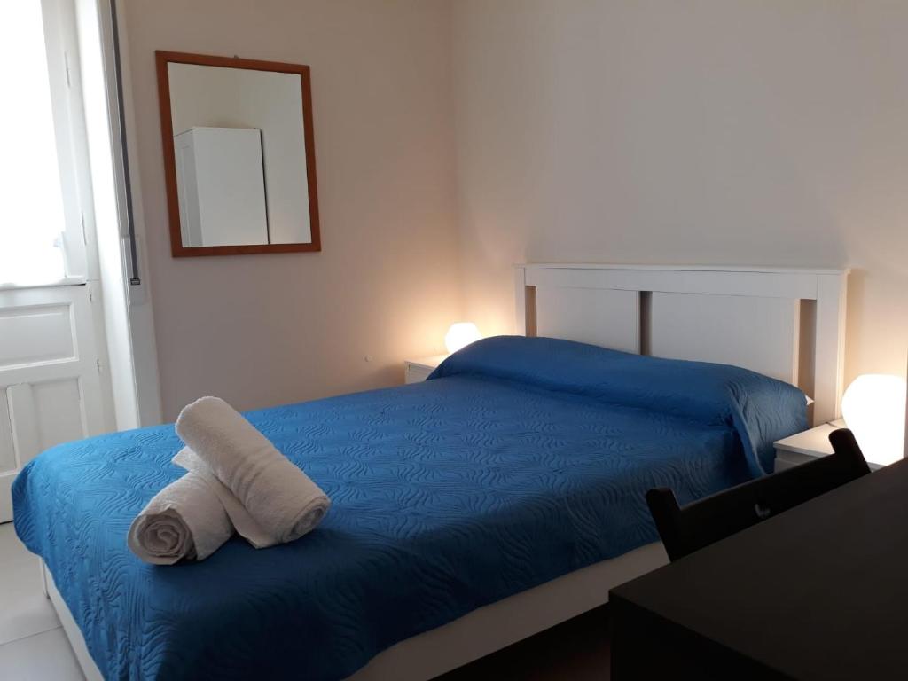 um quarto com uma cama azul com toalhas em Il gelsomino em Scicli