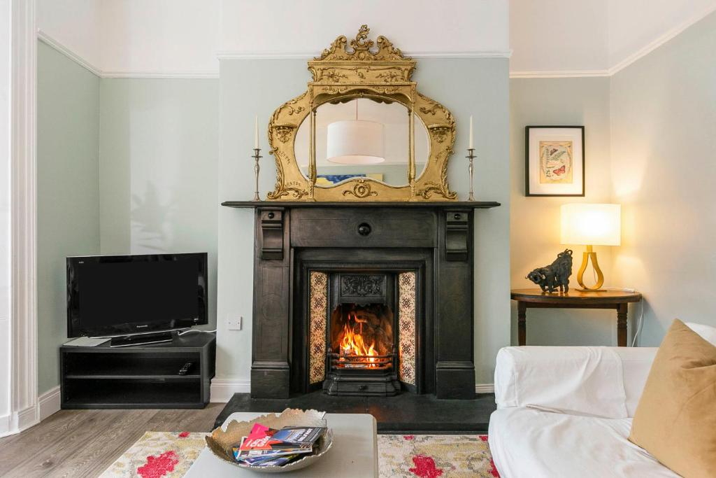 a living room with a fireplace and a mirror at Cyprus View Apartment in Belfast