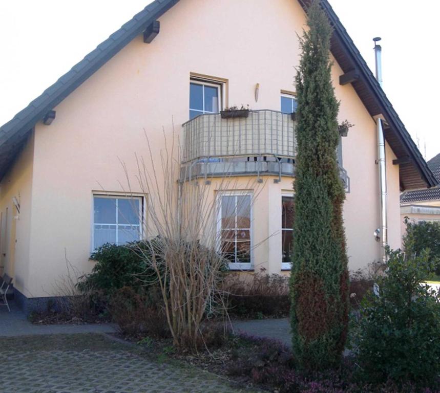 une maison blanche avec un arbre en face dans l'établissement Ferienwohnung Familie Zornow, à Heringsdorf