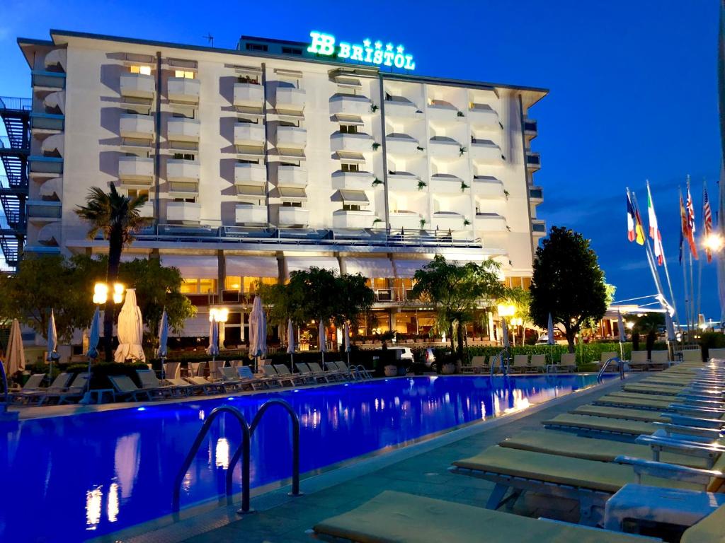 a hotel with a swimming pool in front of a building at Hotel Bristol in Sottomarina