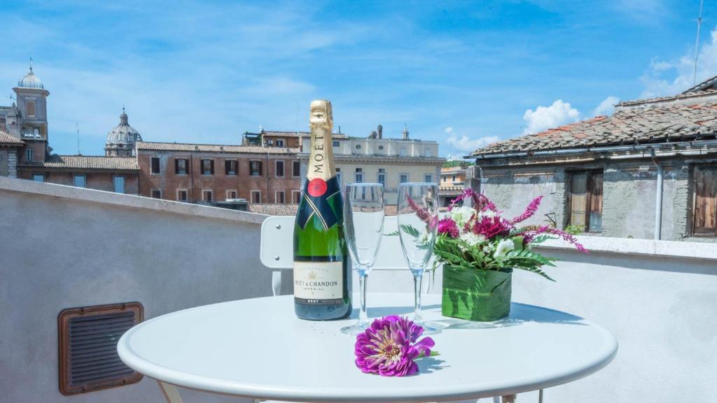 una bottiglia di vino seduta su un tavolo con fiori di Margana Tower a Roma