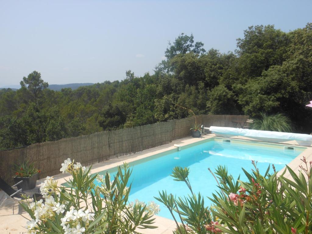 une grande piscine bleue à côté d'un mur en pierre dans l'établissement lou farniente, à Flayosc