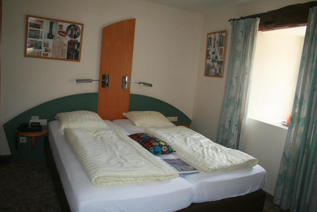 Postel nebo postele na pokoji v ubytování Logis Gourmet & Relax Hotel De La Sure