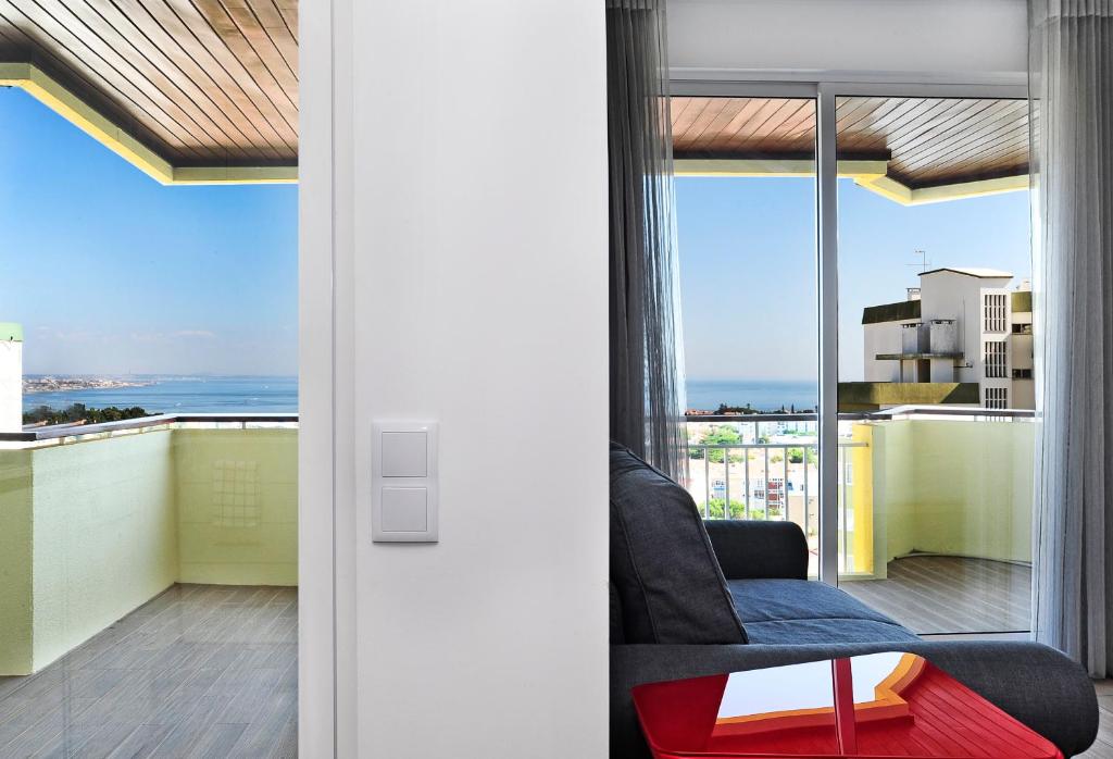 カスカイスにあるSky Panoramic Cascais - comfy studio - Checkinhomeのリビングルーム(椅子付)が備わり、海の景色を望めます。
