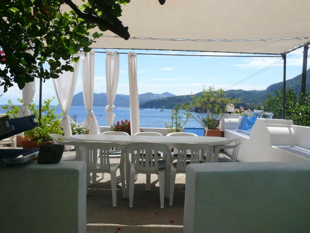 a white table and chairs with a view of the ocean at Casa Athena in Lipari