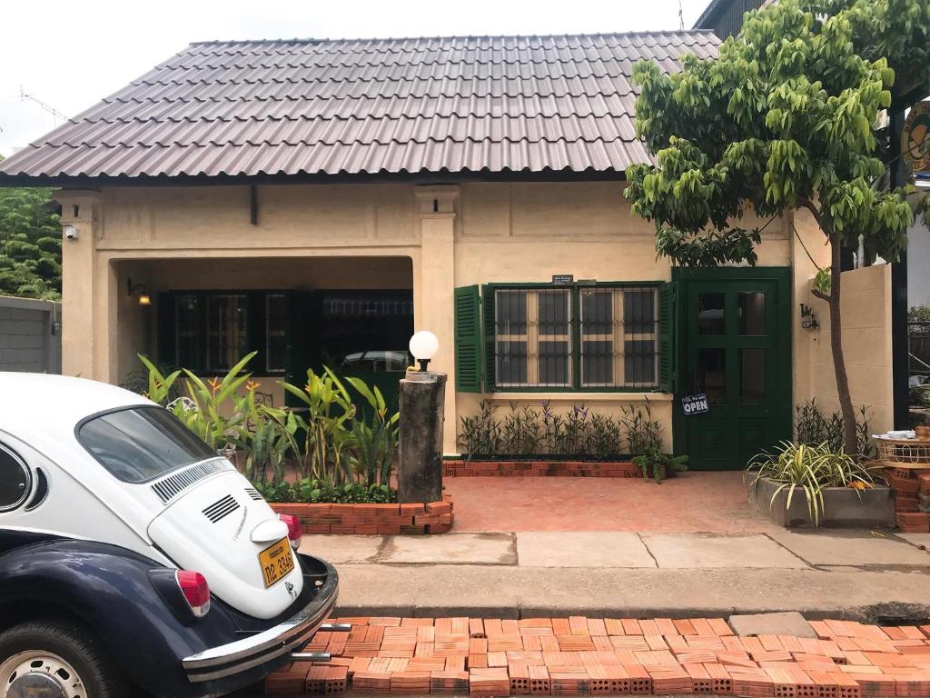 a house with a car parked in front of it at Barn1920s Hostel in Vientiane