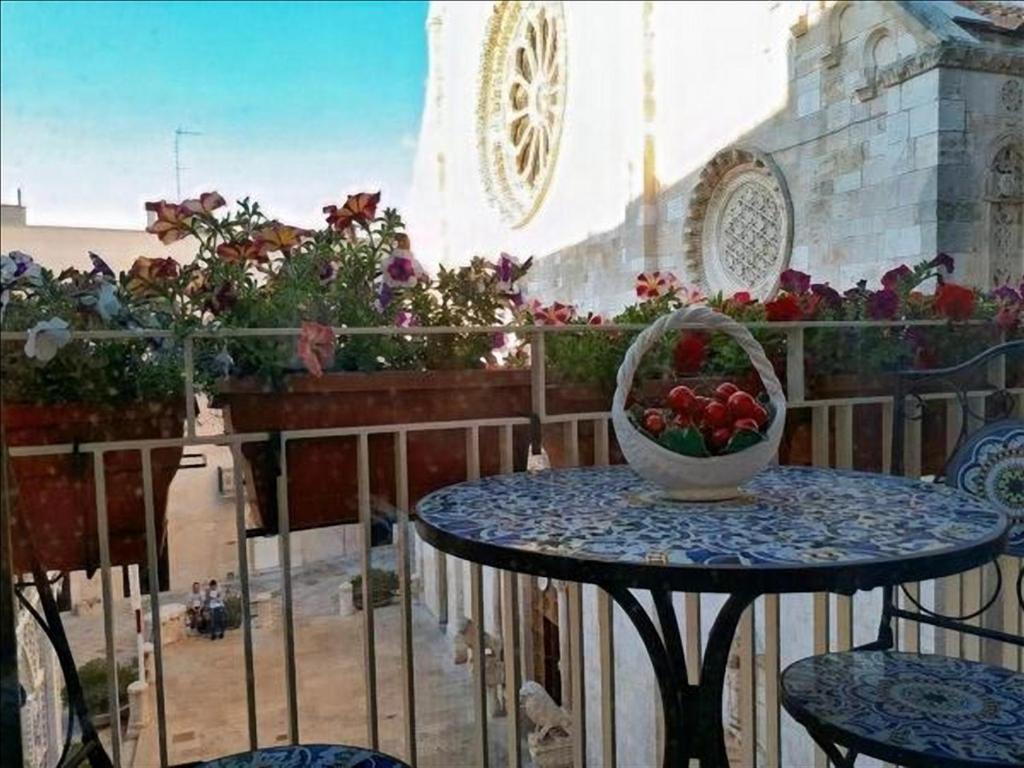 a table with a bowl of fruit on a balcony at Mansarda romantica "Il nido delle rondini" in Conversano