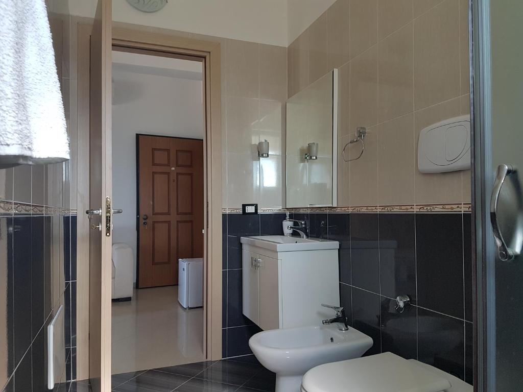 a bathroom with a toilet and a sink and a mirror at Blue Paradise Hotel in Orikum